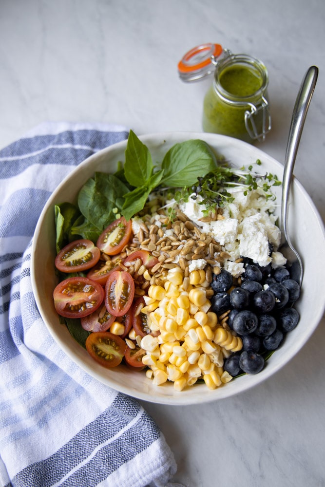 summer grain bowl with cherry tomatoes, corn and blueberries