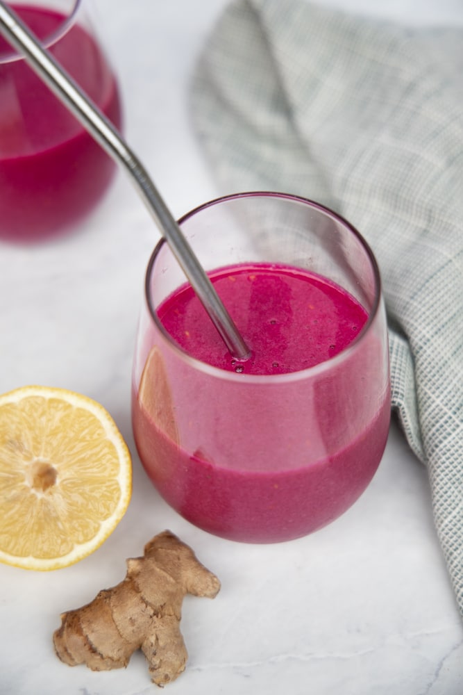 glass filled with beet smoothie and a metal straw