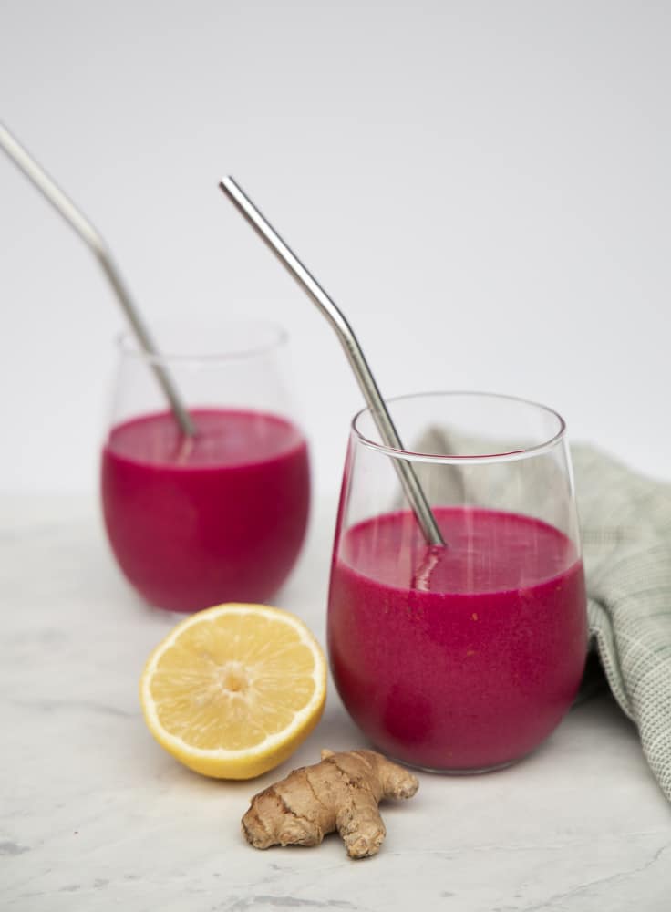 two wine glasses filled with the beet smoothie mix