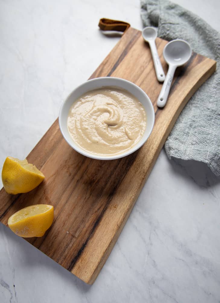 bowl of maple tahini dressing on a cutting board