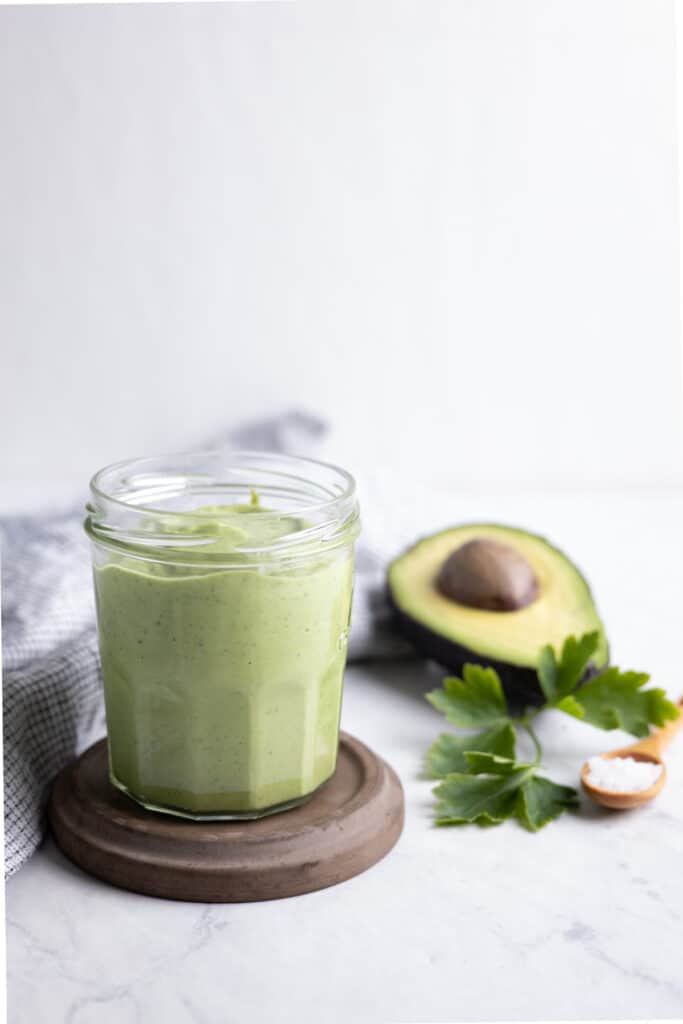 glass jar filled with avocado tahini sauce