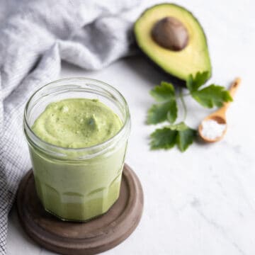 glass jar filled with avocado tahini sauce