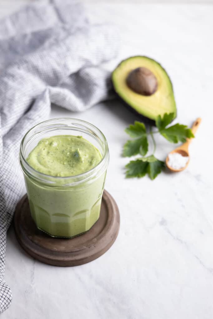 glass jar filled with avocado tahini sauce