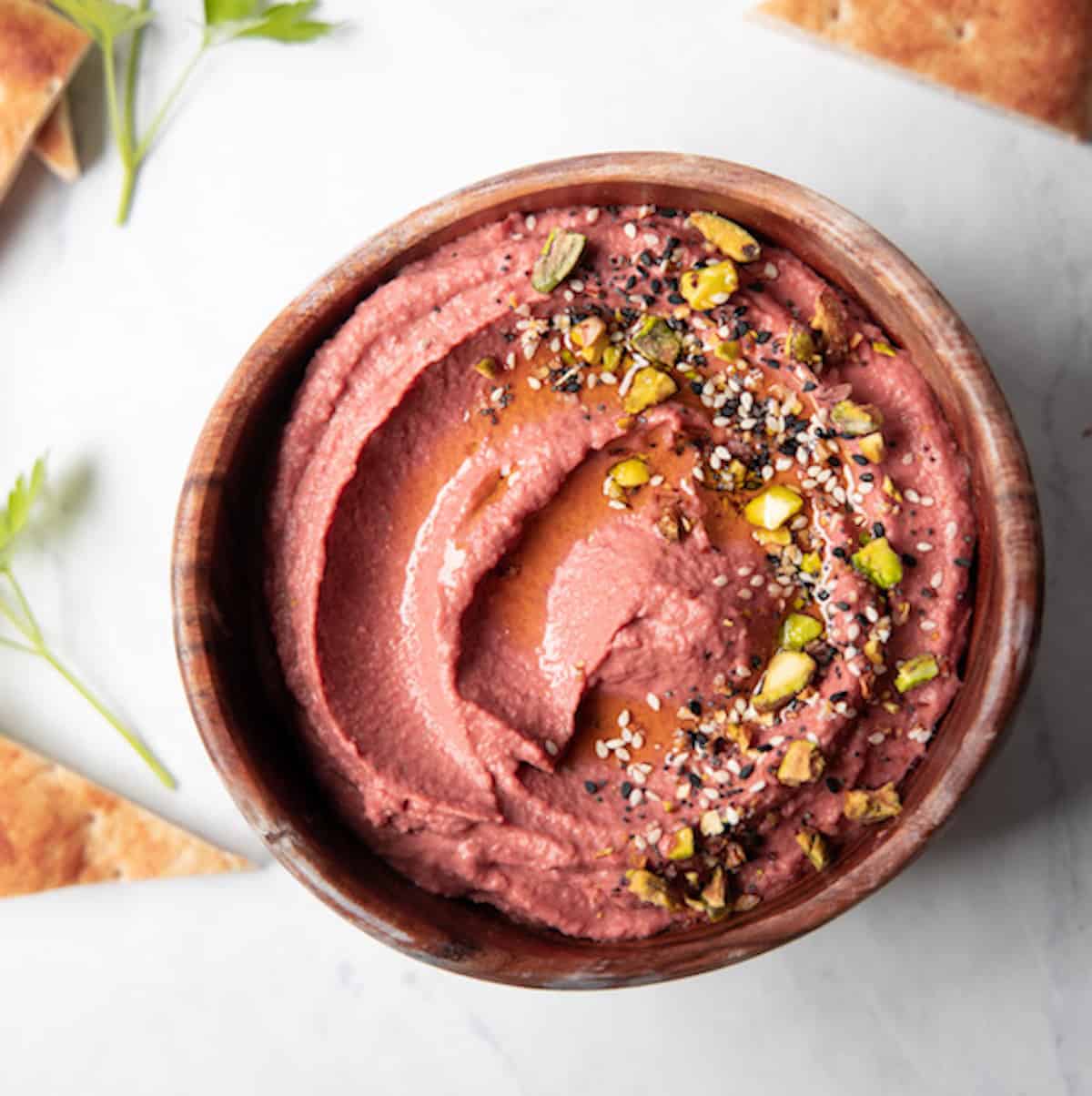 wooden bowl filled with pink beet hummus