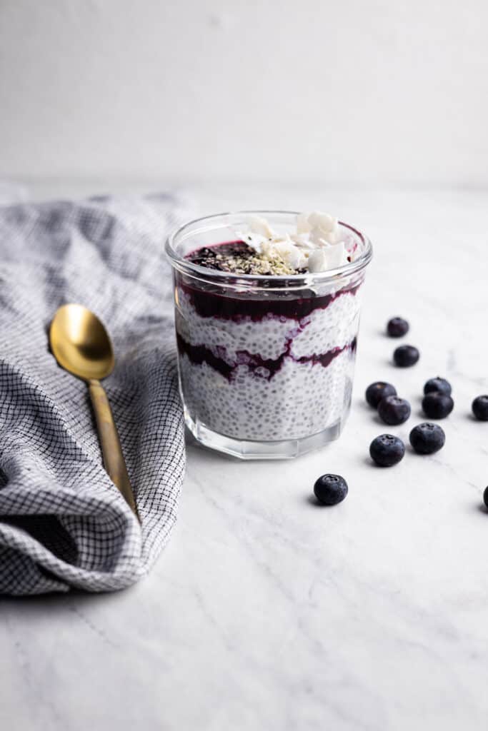 mason jar filled with coconut chia pudding and layers of blueberry compote