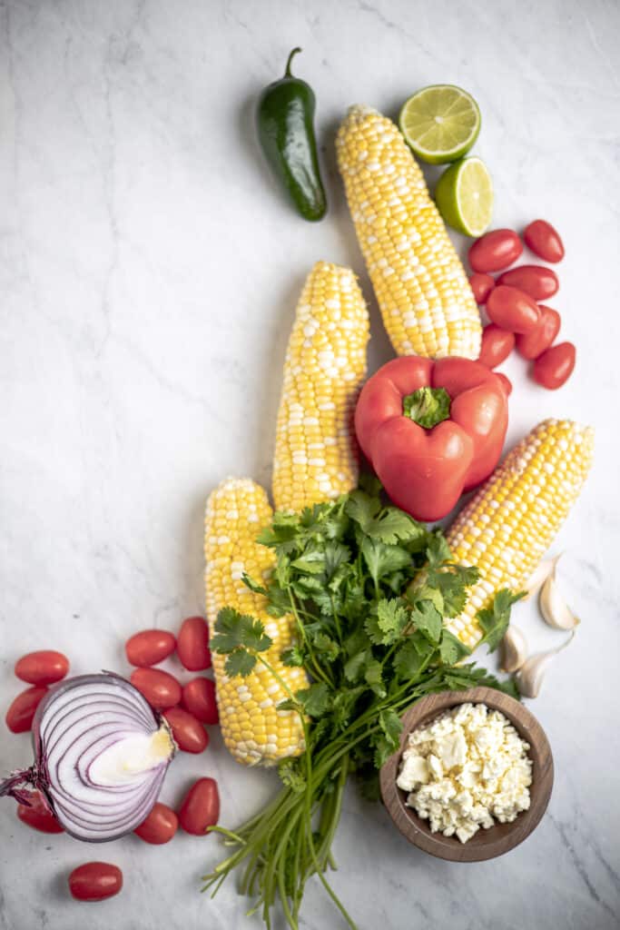 all of the ingredients for corn salad laid out onto a table