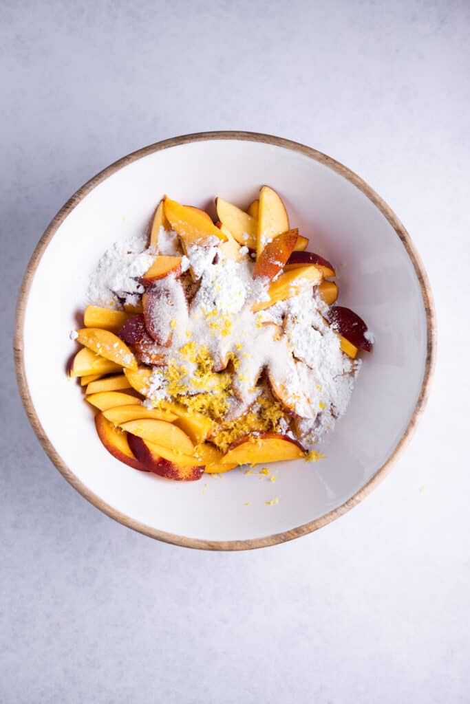 sliced nectarines, cornstarch and lemon zest in a bowl