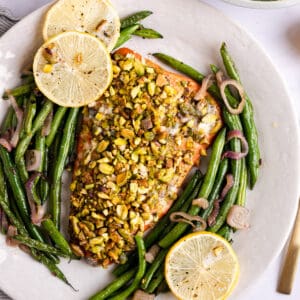 overhead photo of salmon crusted with pistachio and roasted green beans
