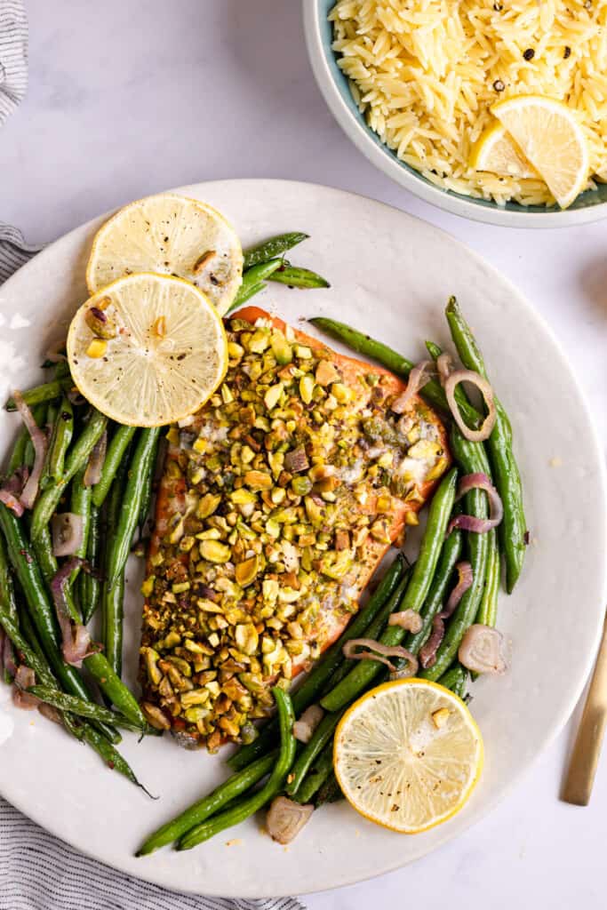 Salmon with pistachio crust on a platter with green beans