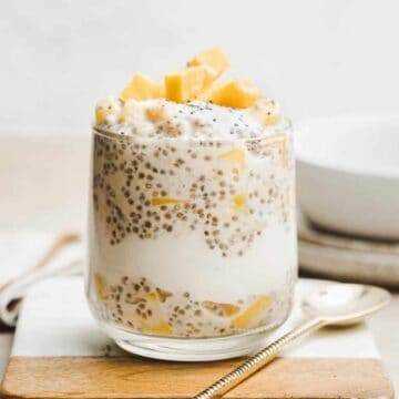 Glass cup filled with tropical overnight oats.