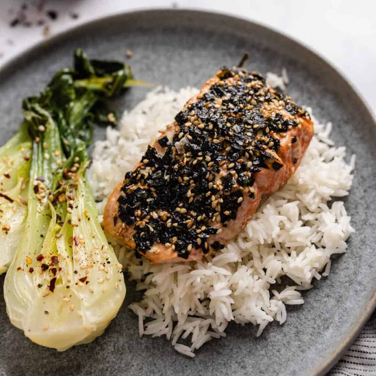 Furikakae salmon on a bed of white rice with a side of bok choy.