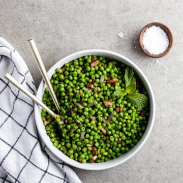 Peas and pancetta with mint in a serving bowl.
