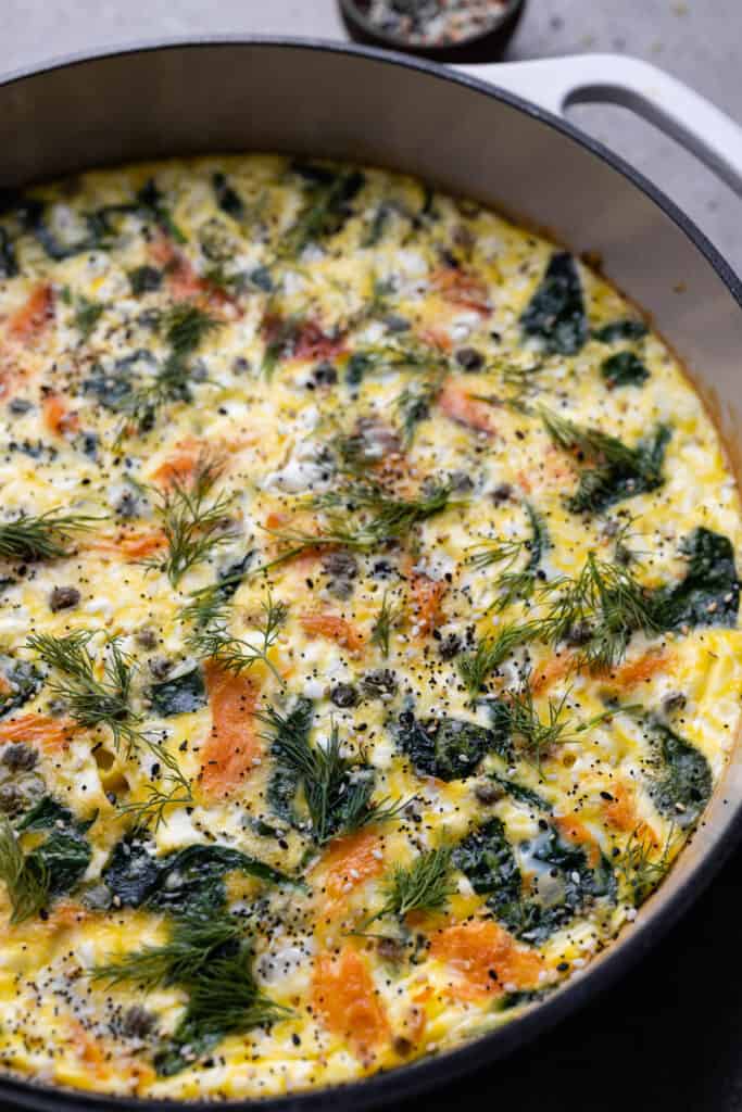 White cast iron pan with smoked salmon fritatta.