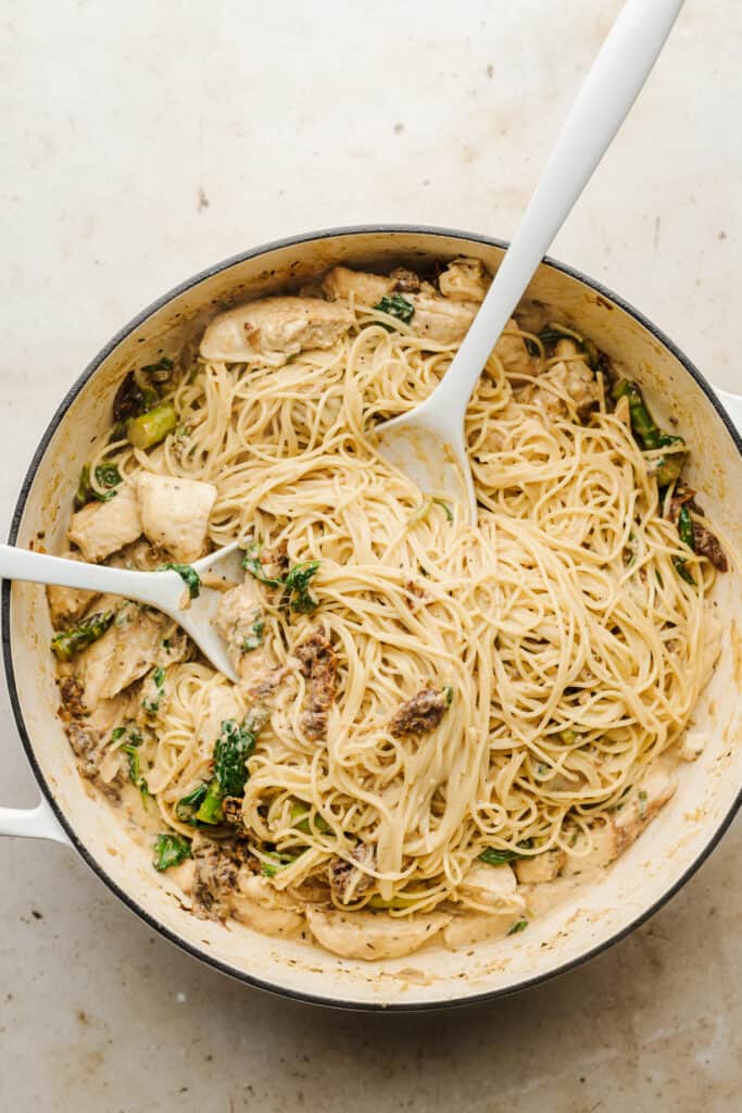 Angel hair pasta and chicken added to skillet.