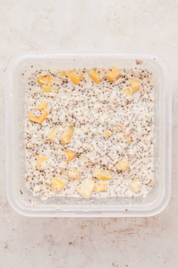 Tropical overnight oats mix in a plastic container to chill.