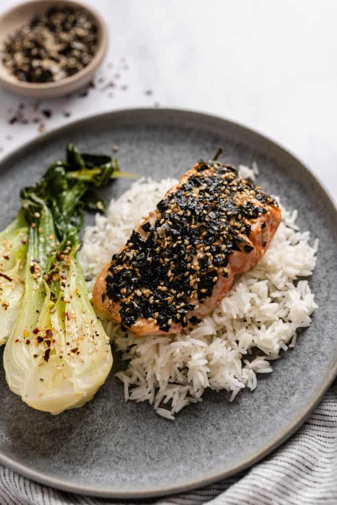 Furikake salmon filet on a bed of white rice with a side of bok choy.